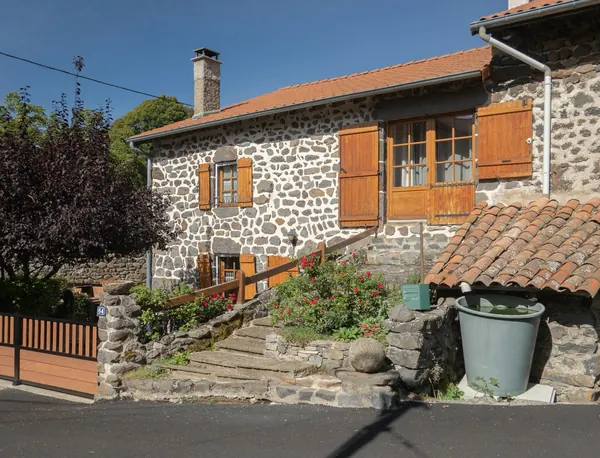 Maison de pays en pierre aux volets repeints